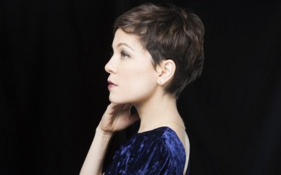 a person in a purple gown with a black background 
