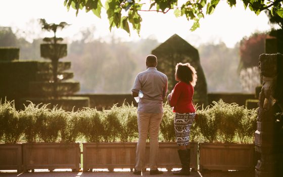 two people turned away looking at a topiary garden