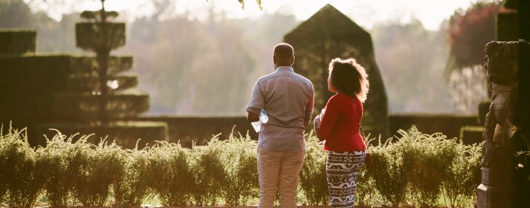 two people turned away looking at a topiary garden