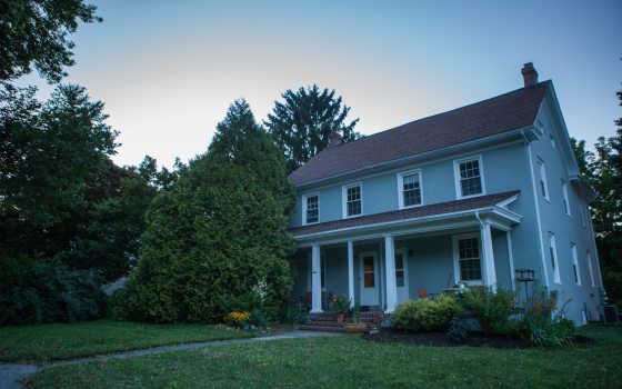 a big, blue house surrounded by trees 