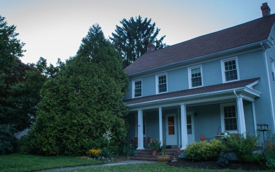 a big, blue house surrounded by trees 