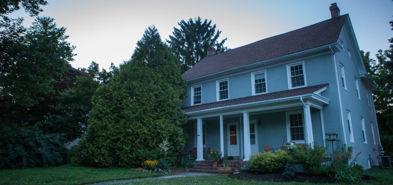 a big, blue house surrounded by trees 