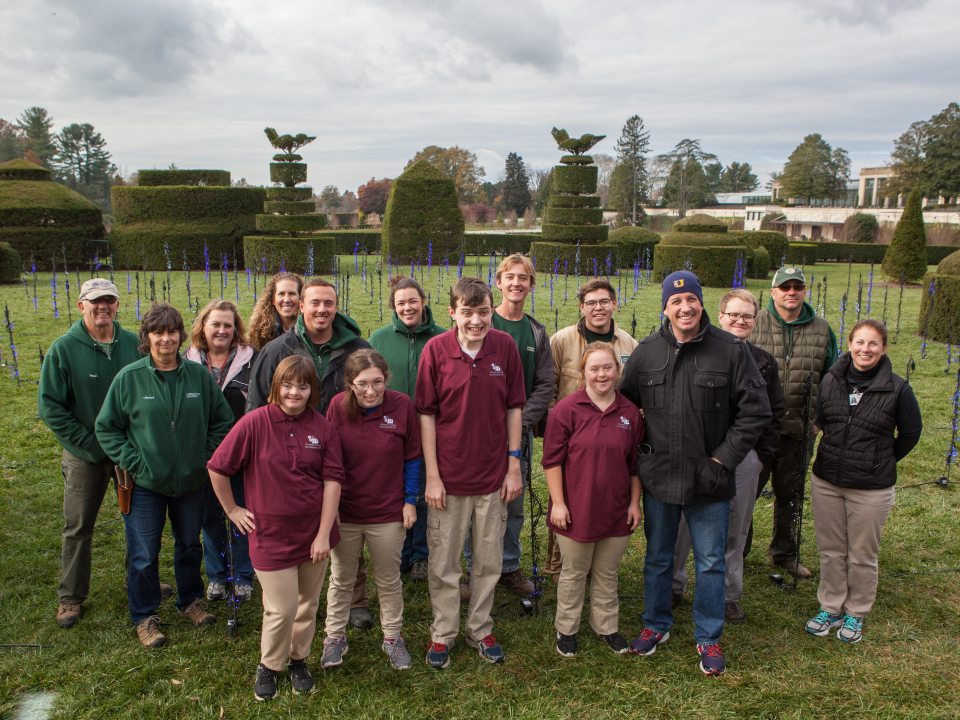 a group of children smiling for the camera with topiaries in the background