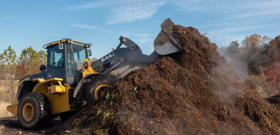 A bulldozer moving a large pile of dirt. 