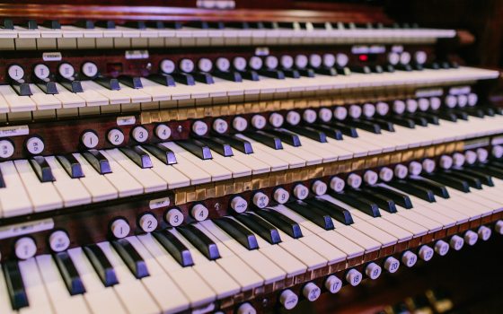 A close up of an organ console and keys.