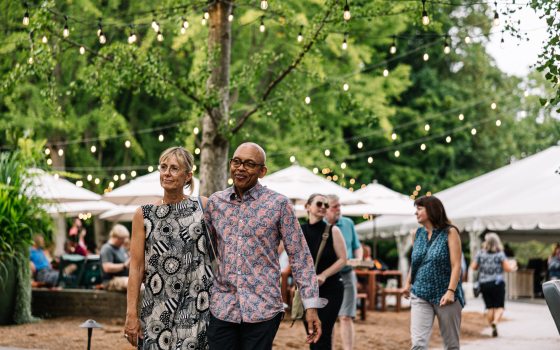 Two people with their arms around each other walking down a path at Longwood Gardens.