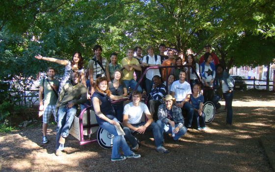 a group of people sitting and standing on a truck 