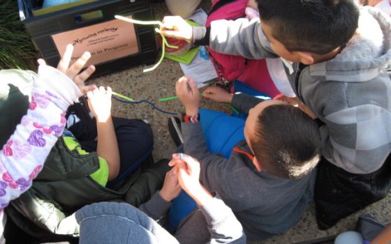 A group of young students sitting in a circle working on a craft.
