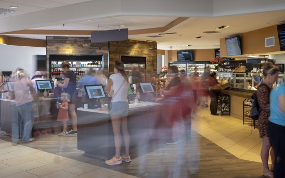 People select and pay for food items in a self-serve café.