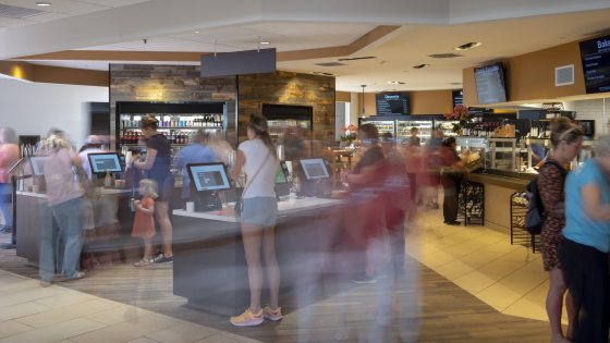 People select and pay for food items in a self-serve café.