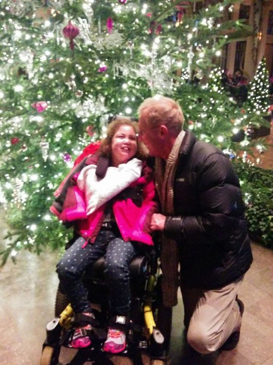 a person and a child in front of a Christmas tree 