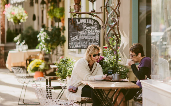 Two people dining at a small table outdoors